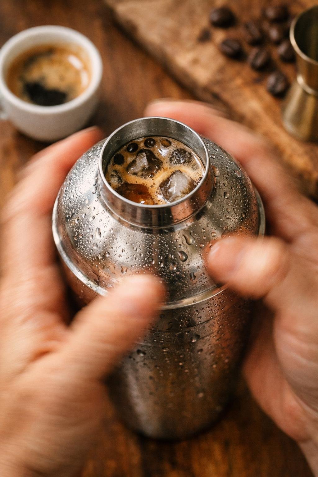 Shaking espresso and brown sugar syrup with ice to make iced shaken espresso at home